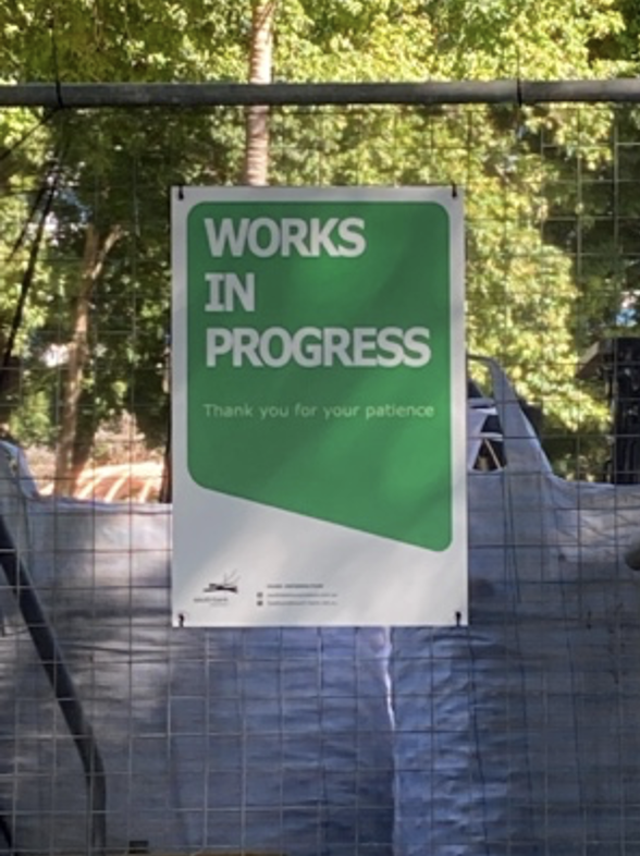 A green sign saying 'Works in Progress'